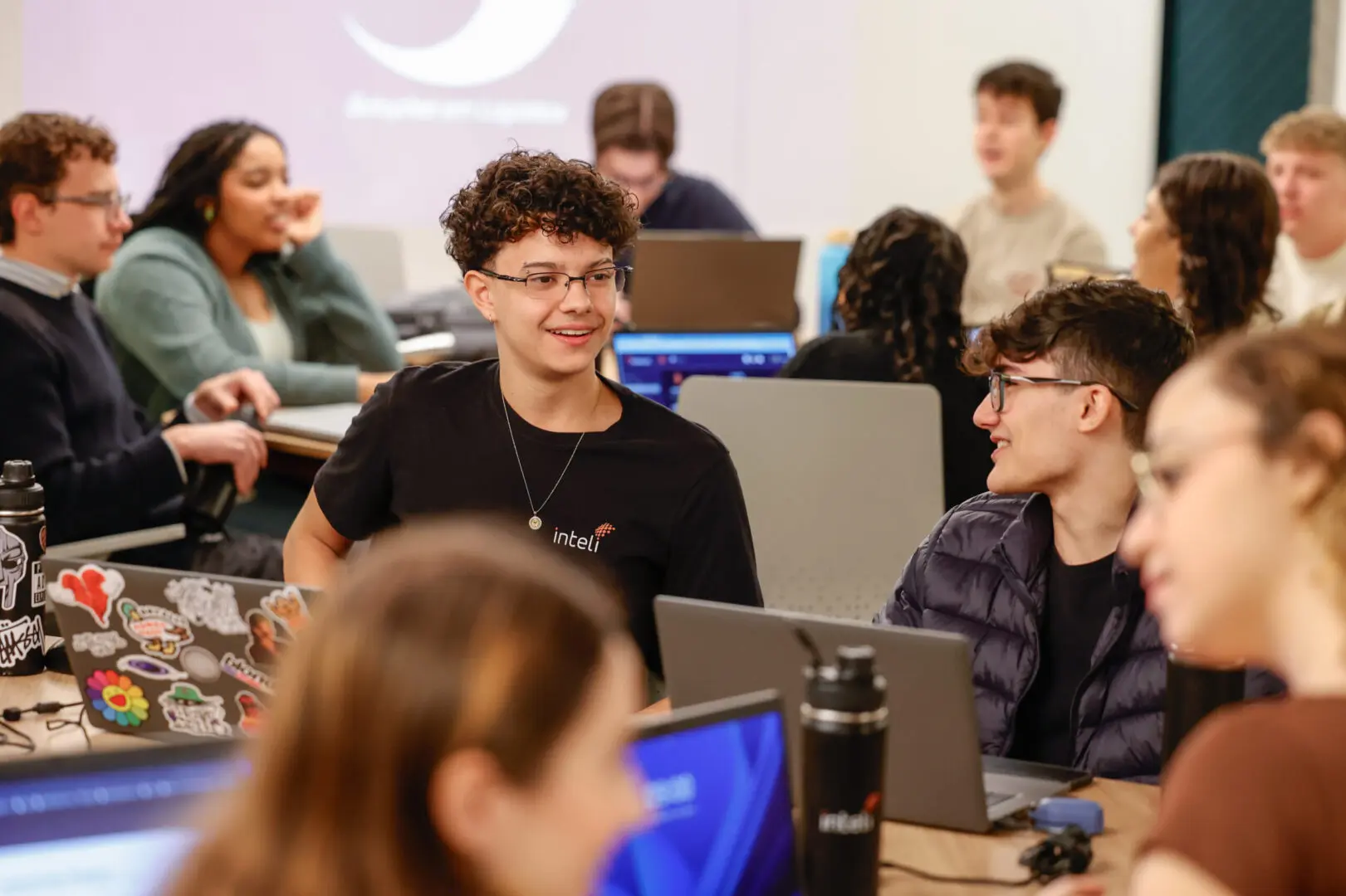 Sala de aula universitária com estudantes utilizando computadores durante uma atividade acadêmica.
